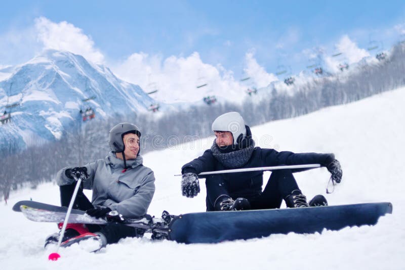 El esquiador y el snowboarder después del resto del esquí y de la snowboard, sientan la charla, risa contra la perspectiva de las imágenes de archivo libres de regalías El esquiador y el snowboarder después del resto del esquí y de la snowboard, sientan la charla, risa contra la perspectiva de las imágenes de archivo libres de regalías