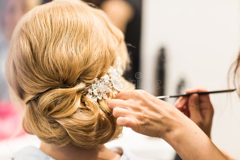El estilista hace a la novia antes de una boda foto de archivo El estilista hace a la novia antes de una boda foto de archivo