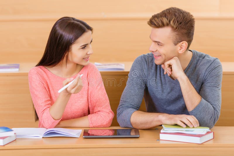 El Companero De Clase In English El Estudiante Joven Está Charlando Con Su Compañero De Clase Imagen de