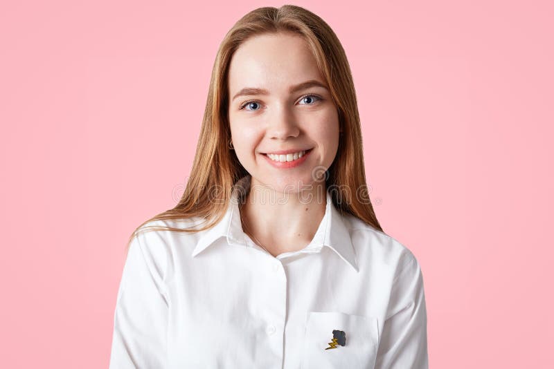 El estudiante joven hermoso tiene piel sana, ojos azules y la sonrisa positiva, lleva la camisa elegante blanca, presenta contra imagen de archivo El estudiante joven hermoso tiene piel sana, ojos azules y la sonrisa positiva, lleva la camisa elegante blanca, presenta contra imagen de archivo