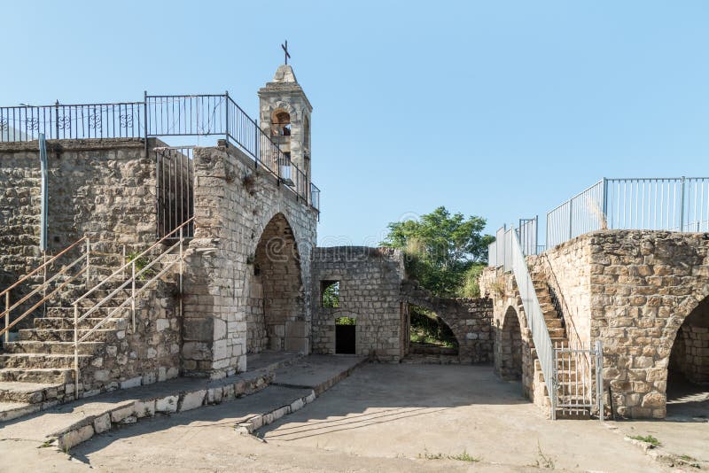 El fasade con el campanario de la iglesia de funcionamiento de Christian Maronites en el pueblo abandonado Kafr Birim en el o del
