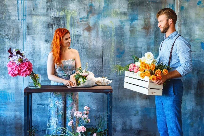 El florista de sexo masculino que sostenía la caja de madera con las flores en fondo azul trajo las flores de la entrega a la hem imágenes de archivo libres de regalías El florista de sexo masculino que sostenía la caja de madera con las flores en fondo azul trajo las flores de la entrega a la hem imágenes de archivo libres de regalías