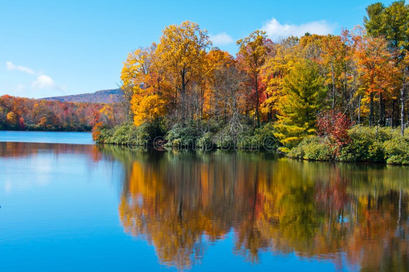 El follaje de caída reflejó en un lago, Ridge azul Pkwy.