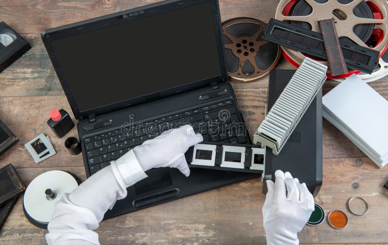 El fot?grafo de la mano convierte la diapositiva de pel?cula a digital para ahorrar fotos de archivo libres de regalías El fot?grafo de la mano convierte la diapositiva de pel?cula a digital para ahorrar fotos de archivo libres de regalías