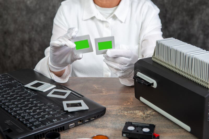 El fot?grafo de la mano convierte la diapositiva de pel?cula a digital para ahorrar foto de archivo libre de regalías El fot?grafo de la mano convierte la diapositiva de pel?cula a digital para ahorrar foto de archivo libre de regalías
