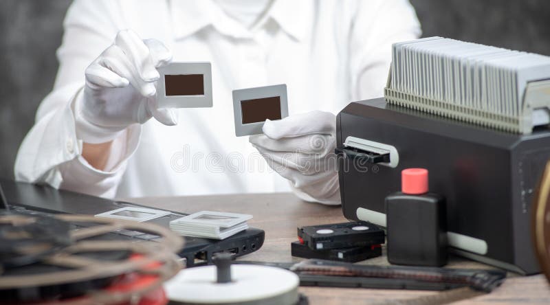 El fot?grafo de la mano convierte la diapositiva de pel?cula a digital para ahorrar foto de archivo libre de regalías El fot?grafo de la mano convierte la diapositiva de pel?cula a digital para ahorrar foto de archivo libre de regalías