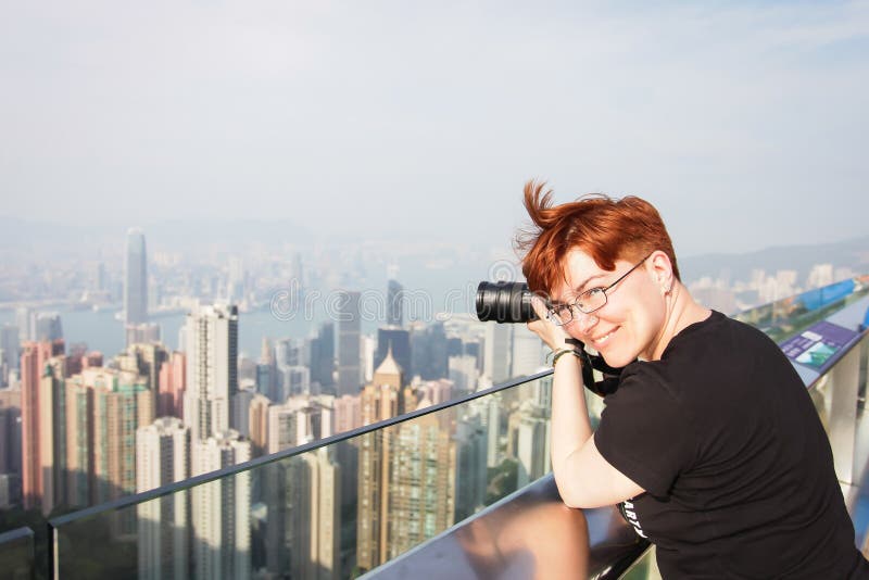 El fotógrafo toma la foto de la ciudad mujer pelirroja que toma imágenes de Hong Kong imagen de archivo libre de regalías El fotógrafo toma la foto de la ciudad mujer pelirroja que toma imágenes de Hong Kong imagen de archivo libre de regalías