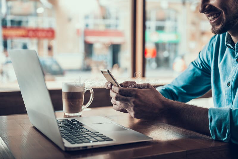 Successful freelancer with laptop is drinking Latte in coffee shop. Coffee break of manager. Successful freelancer with laptop is drinking Latte in coffee shop. Coffee break of manager.