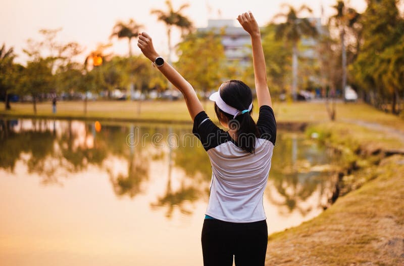 El goce y la libertad asiáticos felices de la mujer con las manos abiertas en puesta del sol, las manos femeninas de la subida pa fotografía de archivo libre de regalías El goce y la libertad asiáticos felices de la mujer con las manos abiertas en puesta del sol, las manos femeninas de la subida pa fotografía de archivo libre de regalías