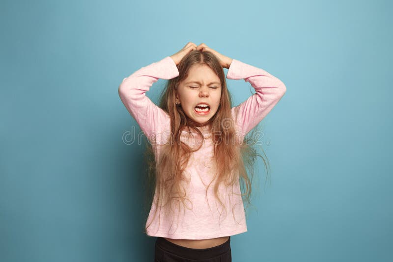 El grito Muchacha adolescente en un fondo azul Expresiones faciales y concepto de las emociones de la gente