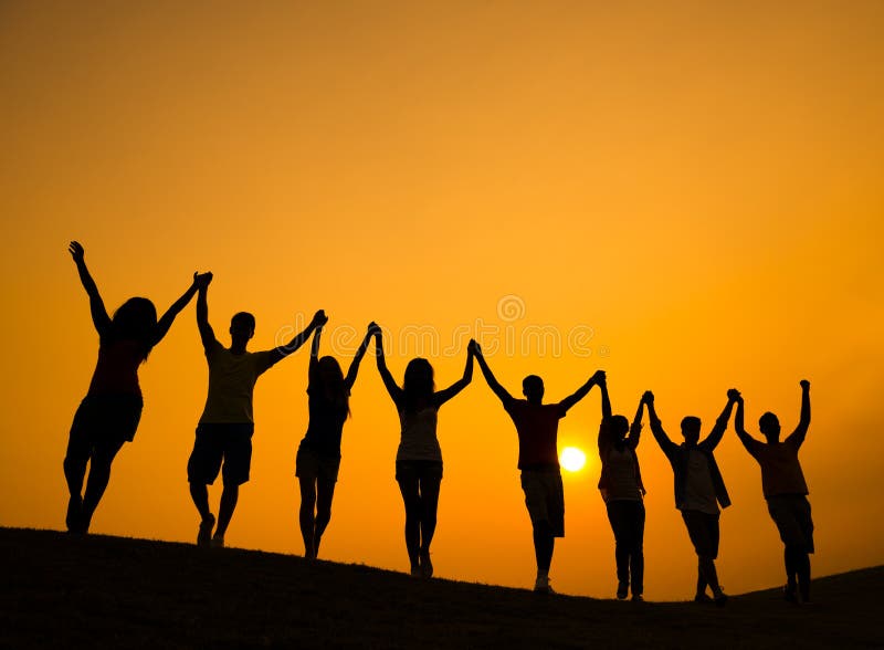 El grupo de adolescentes que llevan a cabo las manos y celebra en Lit trasero