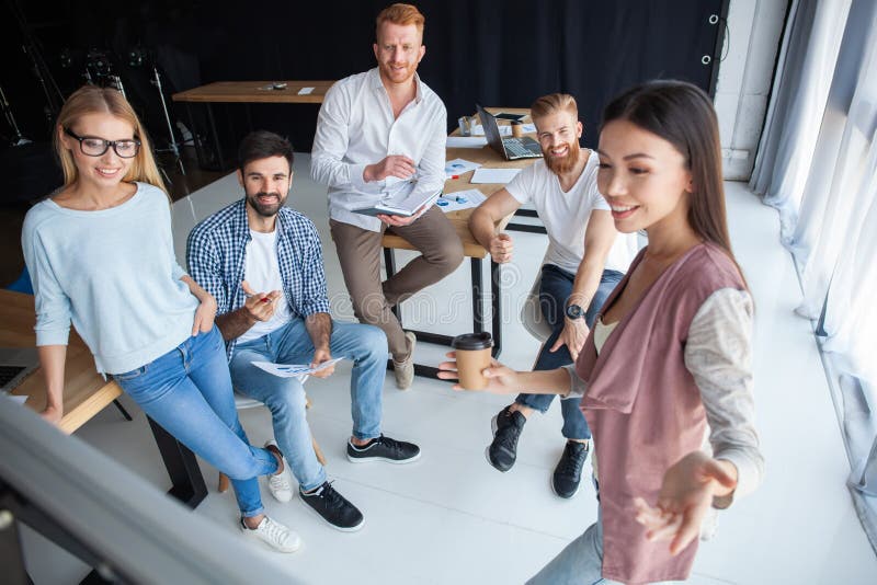 El grupo de colegas jovenes vistió la situación casual junto en oficina moderna y la reunión de reflexión foto de archivo libre de regalías El grupo de colegas jovenes vistió la situación casual junto en oficina moderna y la reunión de reflexión foto de archivo libre de regalías