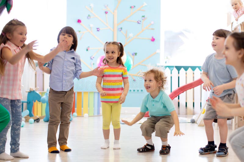 El grupo de niños felices salta interior Los ni? os juegan juntos imágenes de archivo libres de regalías