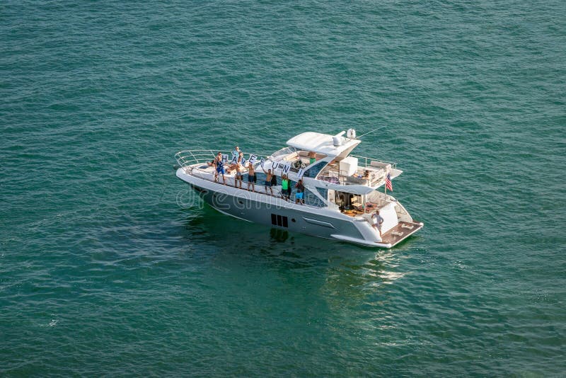 El grupo de personas en el barco de placer soporta la muestra y la onda del de FUN†del “HAVE a los barcos de cruceros de sa foto de archivo libre de regalías