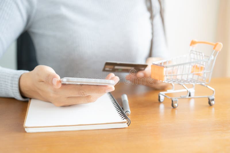 El hacer compras de la mujer en l?nea en carro Mano de la mujer de negocios usando el tel?fono elegante, pagos y celebrar compras imagen de archivo libre de regalías El hacer compras de la mujer en l?nea en carro Mano de la mujer de negocios usando el tel?fono elegante, pagos y celebrar compras imagen de archivo libre de regalías
