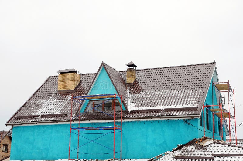 El hogar repara afuera Canal en el top del tejado de la casa Tejado del metal Guardias de la nieve del tejado Tubo de la chimenea imágenes de archivo libres de regalías El hogar repara afuera Canal en el top del tejado de la casa Tejado del metal Guardias de la nieve del tejado Tubo de la chimenea imágenes de archivo libres de regalías