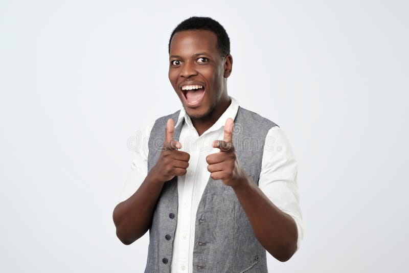 El hombre africano hermoso joven con dos armas de las manos firma gesto que señala en usted la cámara imagenes de archivo El hombre africano hermoso joven con dos armas de las manos firma gesto que señala en usted la cámara imagenes de archivo