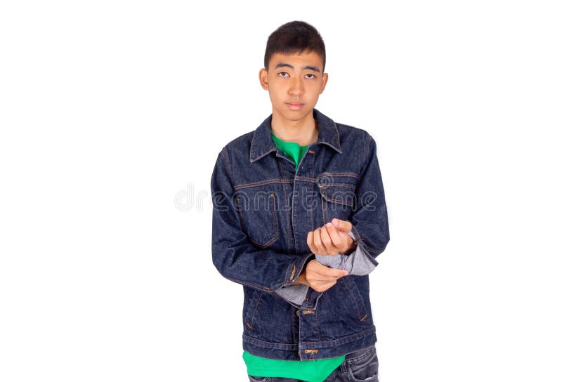 El hombre asiático joven en camiseta verde está poniendo en la chaqueta de los vaqueros imagen de archivo El hombre asiático joven en camiseta verde está poniendo en la chaqueta de los vaqueros imagen de archivo