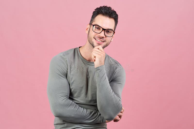 El hombre atlético joven con los vidrios con una sonrisa positiva mira cuidadosamente la cámara y sonríe fotos de archivo El hombre atlético joven con los vidrios con una sonrisa positiva mira cuidadosamente la cámara y sonríe fotos de archivo