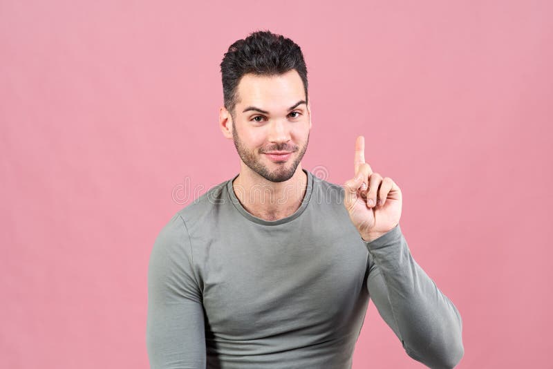 El hombre blanco-pelado deportivo en una camiseta gris aumenta su finger para arriba y le deja entusiasta saber que él tenía una fotografía de archivo libre de regalías El hombre blanco-pelado deportivo en una camiseta gris aumenta su finger para arriba y le deja entusiasta saber que él tenía una fotografía de archivo libre de regalías