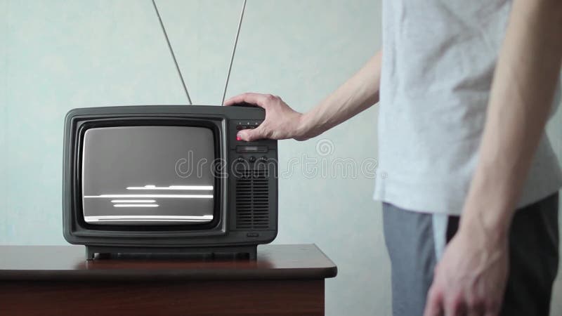 El hombre cambia los canales en la TV vieja