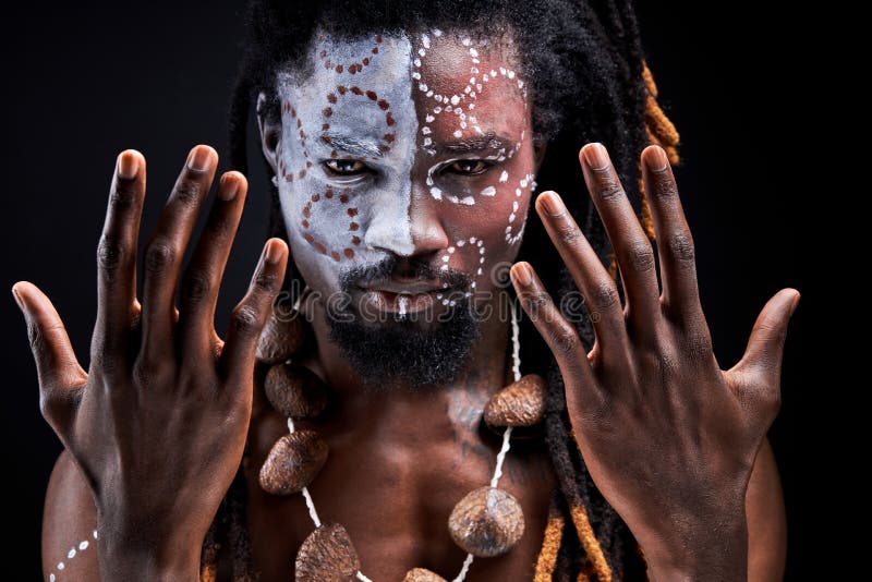 El hombre chamánico africano está haciendo rituales extendiendo sus manos imagen de archivo