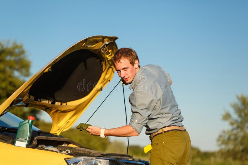 El hombre comprueba el nivel de aceite imagen de archivo