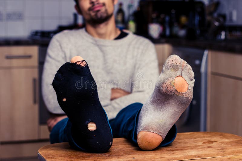 El hombre con usado pega la relajación en cocina imagen de archivo