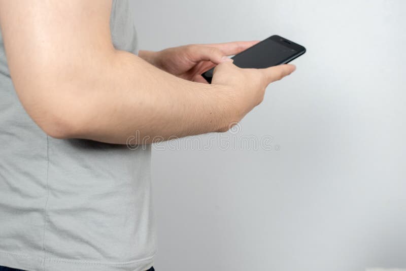 El hombre consume su teléfono móvil, cierre imagen de archivo El hombre consume su teléfono móvil, cierre imagen de archivo