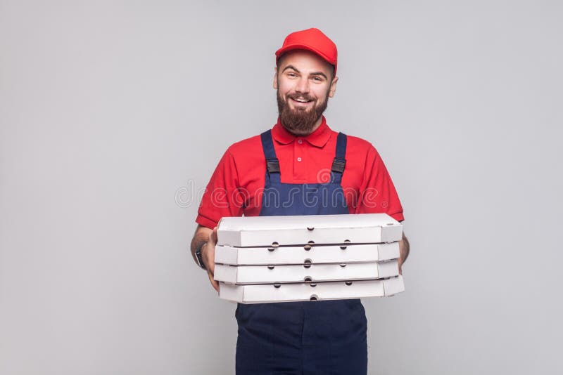 El hombre de entrega logístico sonriente de los jóvenes con la barba en azul uniforma a imágenes de archivo libres de regalías El hombre de entrega logístico sonriente de los jóvenes con la barba en azul uniforma a imágenes de archivo libres de regalías