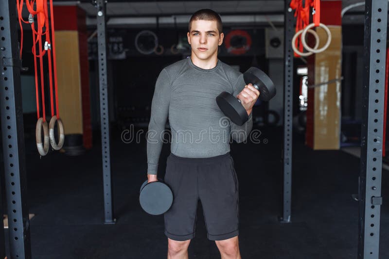 El hombre de los deportes aumenta pesos en el entrenamiento en el gimnasio, entrenamiento de la mañana fotografía de archivo libre de regalías El hombre de los deportes aumenta pesos en el entrenamiento en el gimnasio, entrenamiento de la mañana fotografía de archivo libre de regalías