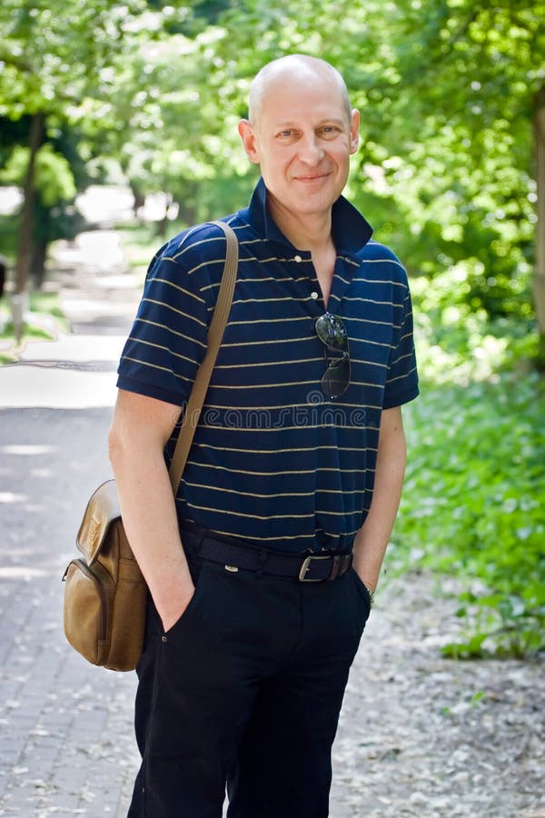 El hombre de mediana edad camina en un parque del verano fotos de archivo libres de regalías El hombre de mediana edad camina en un parque del verano fotos de archivo libres de regalías