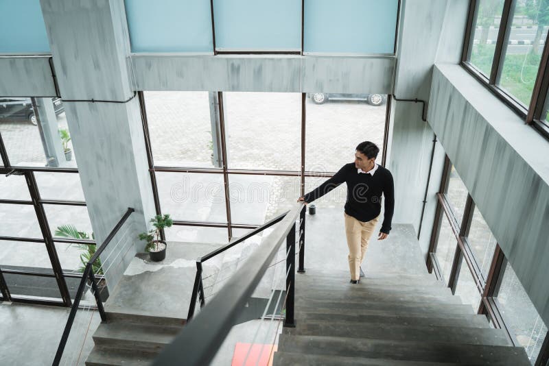 El hombre de negocios asiático que camina para arriba en las escaleras va a su sitio en arriba imagenes de archivo El hombre de negocios asiático que camina para arriba en las escaleras va a su sitio en arriba imagenes de archivo