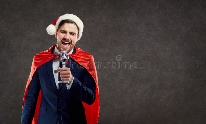 El hombre de negocios en super héroe del traje de Santa Claus canta la canción foto de archivo libre de regalías El hombre de negocios en super héroe del traje de Santa Claus canta la canción foto de archivo libre de regalías