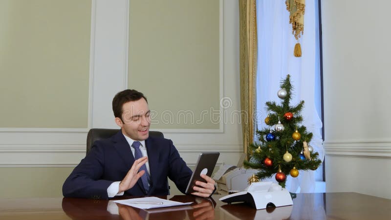 El hombre de negocios felicita a socios comerciales con la Navidad vía Internet con la tableta imagenes de archivo El hombre de negocios felicita a socios comerciales con la Navidad vía Internet con la tableta imagenes de archivo