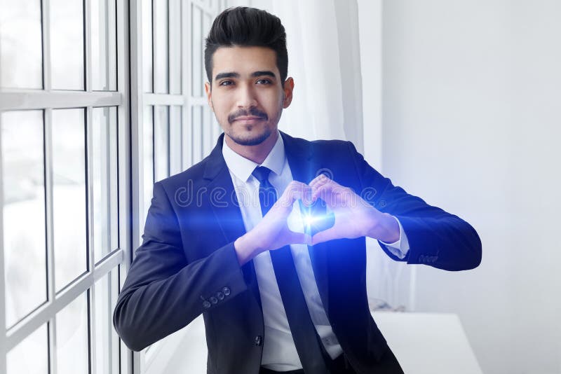 El hombre de negocios joven en amor muestra la muestra del corazón imágenes de archivo libres de regalías El hombre de negocios joven en amor muestra la muestra del corazón imágenes de archivo libres de regalías