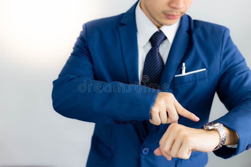 El hombre de negocios joven hermoso atractivo está mirando el tiempo en wri fotos de archivo El hombre de negocios joven hermoso atractivo está mirando el tiempo en wri fotos de archivo