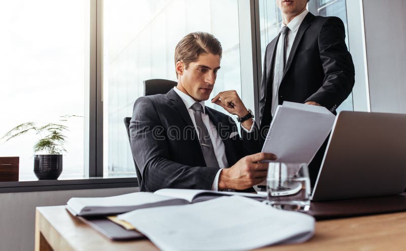 El hombre de negocios partners la lectura de un cierto papeleo foto de archivo libre de regalías El hombre de negocios partners la lectura de un cierto papeleo foto de archivo libre de regalías