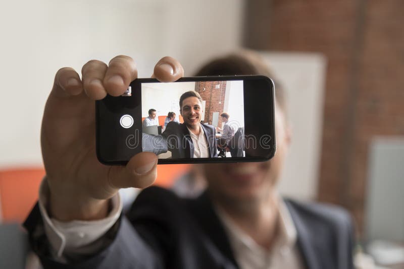 El hombre de negocios sonriente hace la imagen del autorretrato en oficina imágenes de archivo libres de regalías El hombre de negocios sonriente hace la imagen del autorretrato en oficina imágenes de archivo libres de regalías