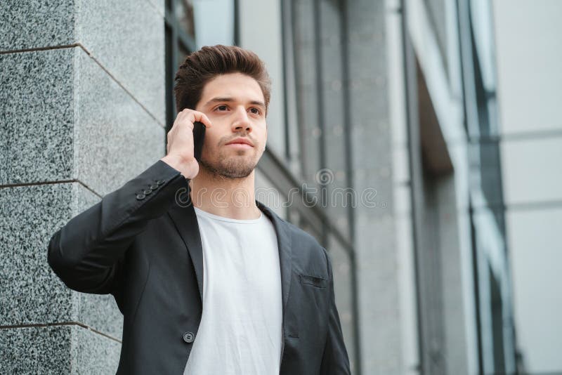 El hombre de negocios tiene conversación seria usando el teléfono celular Individuo del negocio en negociaciones formales del tra fotos de archivo libres de regalías El hombre de negocios tiene conversación seria usando el teléfono celular Individuo del negocio en negociaciones formales del tra fotos de archivo libres de regalías