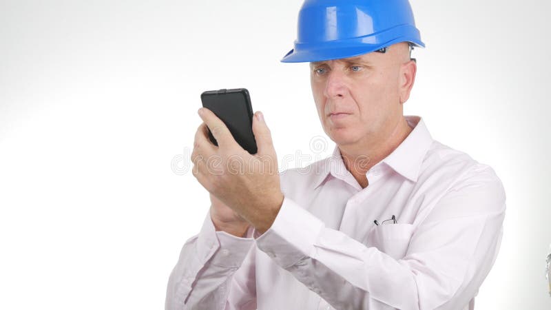 El hombre de negocios Wearing Engineer Helmet comunica usando el teléfono móvil foto de archivo libre de regalías El hombre de negocios Wearing Engineer Helmet comunica usando el teléfono móvil foto de archivo libre de regalías