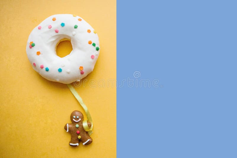 El hombre de pan de jengibre sostiene un buñuelo en su mano que parezca un globo Idea creativa Concepto del día de fiesta Lugar p foto de archivo libre de regalías El hombre de pan de jengibre sostiene un buñuelo en su mano que parezca un globo Idea creativa Concepto del día de fiesta Lugar p foto de archivo libre de regalías