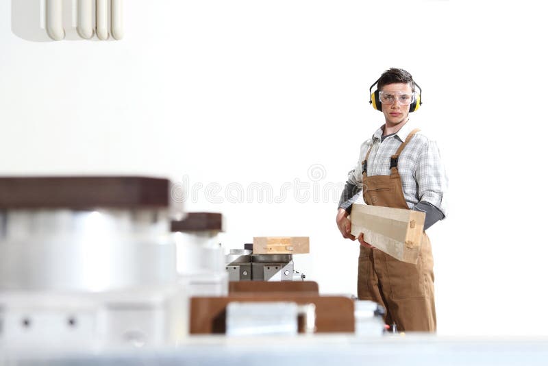 El hombre del carpintero trabaja con los tablones de madera en la carpinter?a, con el centro de control num?rico de ordenador, m? fotos de archivo libres de regalías El hombre del carpintero trabaja con los tablones de madera en la carpinter?a, con el centro de control num?rico de ordenador, m? fotos de archivo libres de regalías