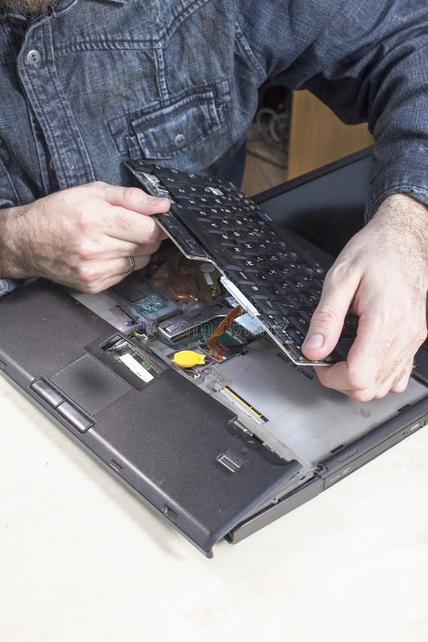 El hombre desmonta la cubierta del ordenador portátil en el servicio de equipo electrónico imagenes de archivo El hombre desmonta la cubierta del ordenador portátil en el servicio de equipo electrónico imagenes de archivo