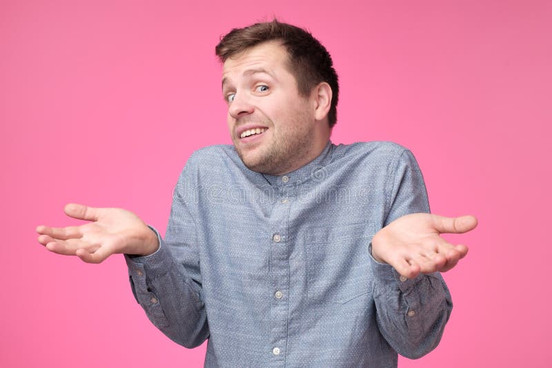 El hombre elegante joven incierto lleva la camisa azul, hombros de los encogimientos de hombros siendo desconcertado o confundido imagenes de archivo El hombre elegante joven incierto lleva la camisa azul, hombros de los encogimientos de hombros siendo desconcertado o confundido imagenes de archivo