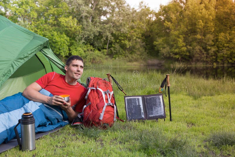 El hombre en el sitio para acampar en el bosque imagen de archivo libre de regalías El hombre en el sitio para acampar en el bosque imagen de archivo libre de regalías