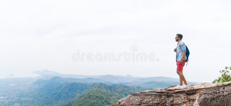 El hombre en el pico de montaña que aumenta las manos con las mochilas disfruta del concepto de la libertad del paisaje, Guy Tour imagen de archivo libre de regalías El hombre en el pico de montaña que aumenta las manos con las mochilas disfruta del concepto de la libertad del paisaje, Guy Tour imagen de archivo libre de regalías
