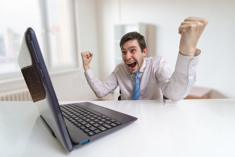 El hombre feliz joven es un ganador Concepto apostador en línea foto de archivo El hombre feliz joven es un ganador Concepto apostador en línea foto de archivo