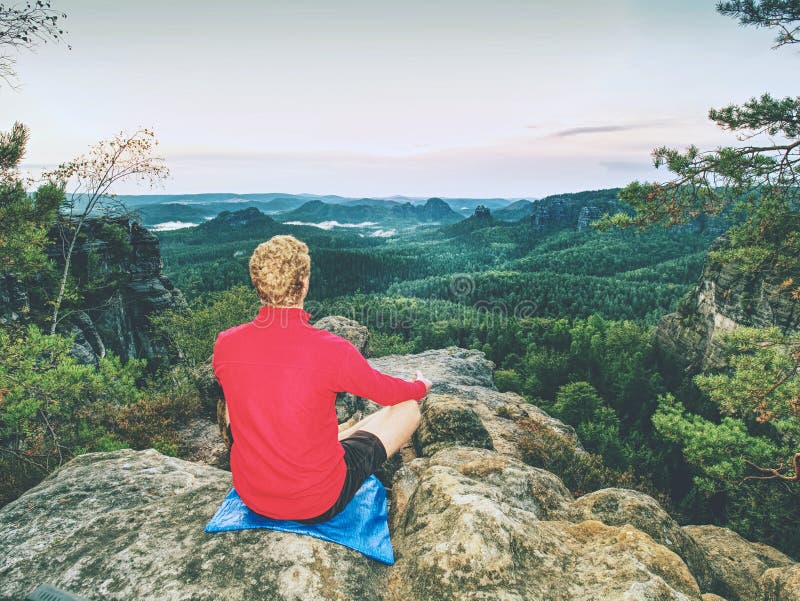 El hombre hace actitud de la yoga en la roca dentro de orning Deportista de mediana edad fotografía de archivo El hombre hace actitud de la yoga en la roca dentro de orning Deportista de mediana edad fotografía de archivo