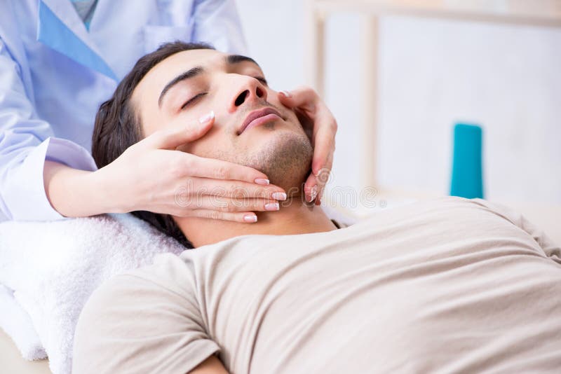 El hombre hermoso joven que visita al cosmetologist femenino del doctor fotografía de archivo El hombre hermoso joven que visita al cosmetologist femenino del doctor fotografía de archivo